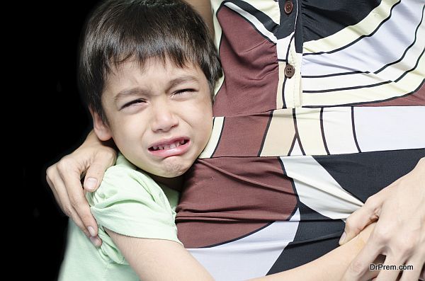 Littleboy crying holding his mother black background